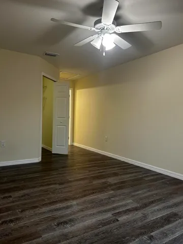 a view of a room with wooden floor and fan