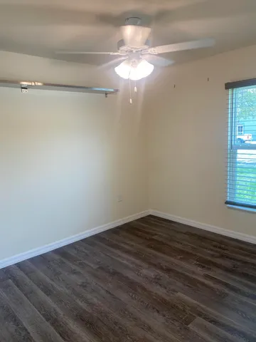 a view of a room with wooden floor and a window