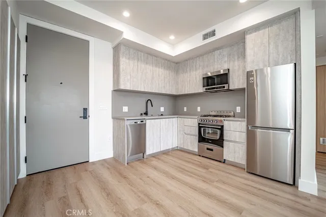 a kitchen with refrigerator cabinets and wooden floor