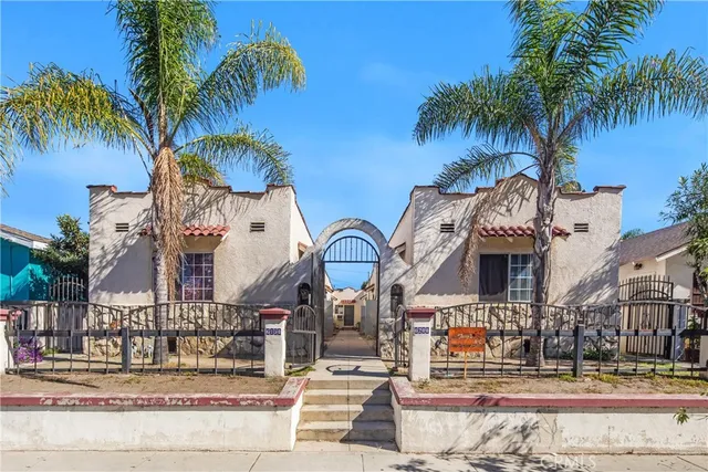 a front view of multiple houses with palm trees