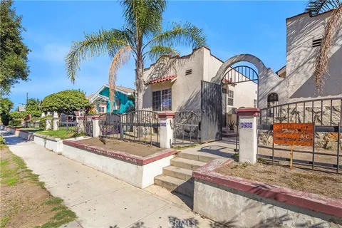 a front view of multiple houses with palm trees
