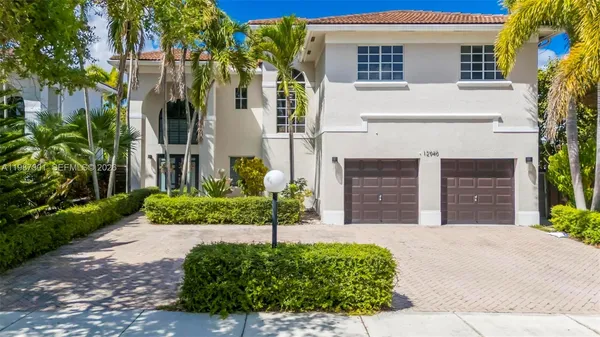 a front view of a house with a yard and potted plants