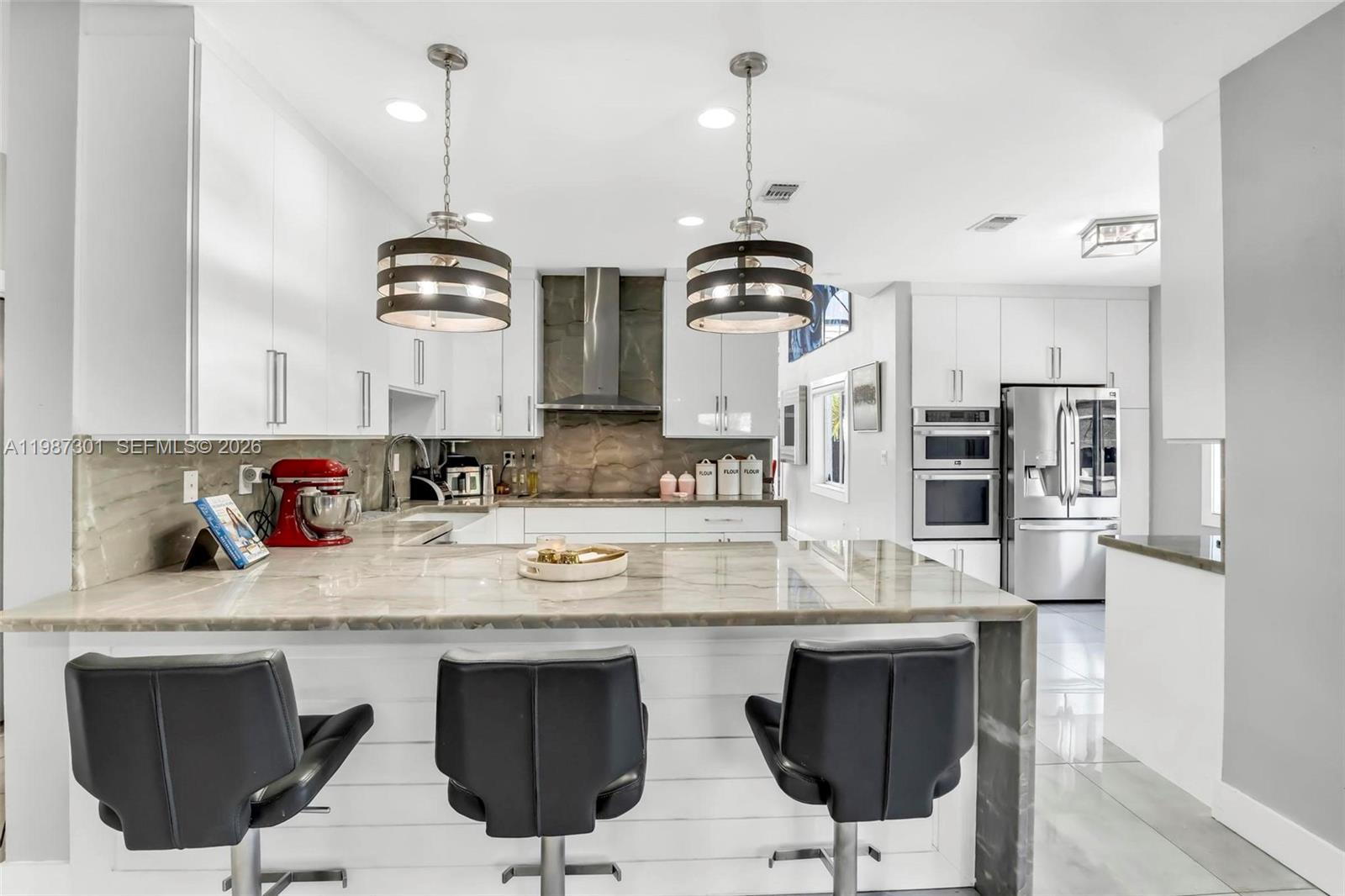 12940 Southwest 142nd Terrace Miami, FL 33186 - Photo 17 of 44 a kitchen with stainless steel appliances granite countertop a sink a stove and chairs