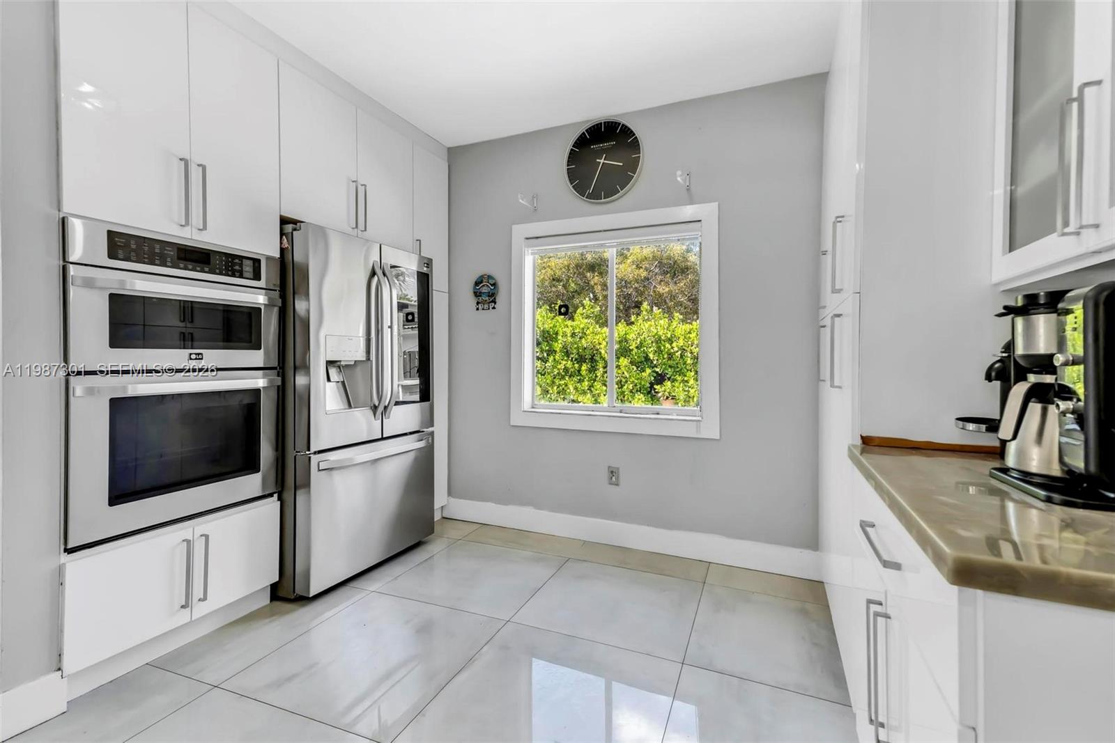 12940 Southwest 142nd Terrace Miami, FL 33186 - Photo 22 of 44 a kitchen with stainless steel appliances a stove a microwave and a refrigerator