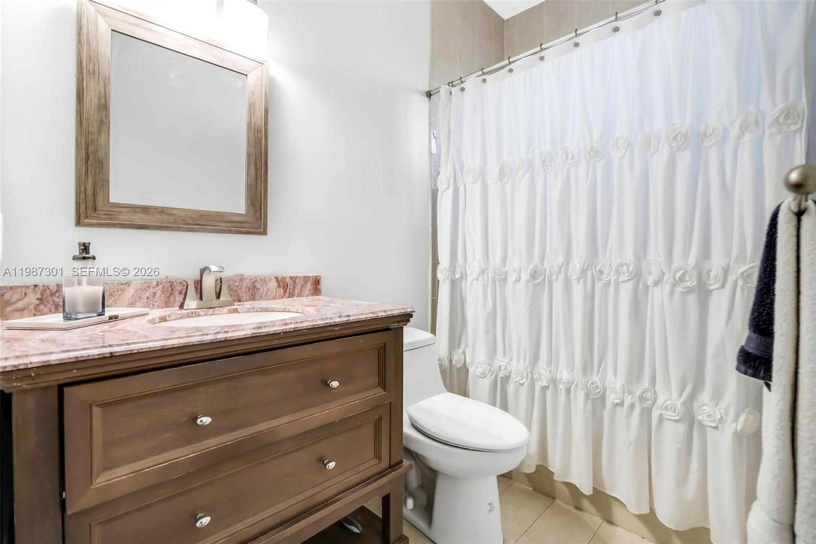 12940 Southwest 142nd Terrace Miami, FL 33186 - Photo 36 of 44 a bathroom with a granite countertop sink toilet and mirror