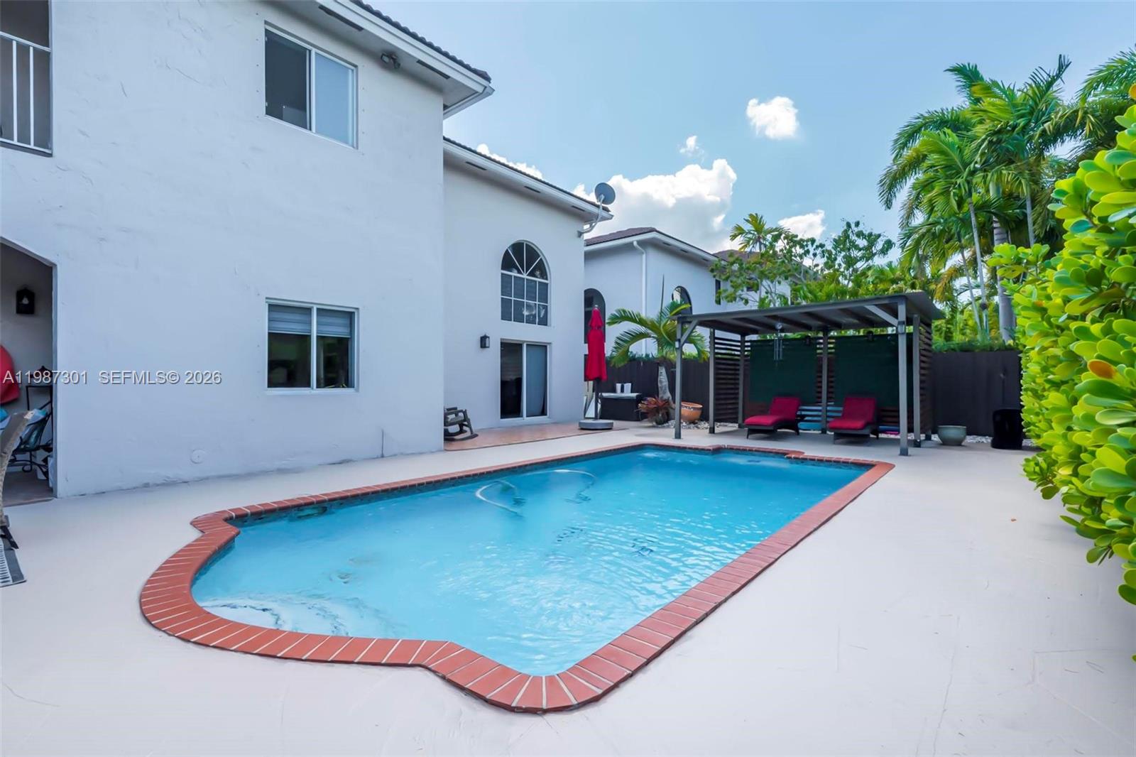 12940 Southwest 142nd Terrace Miami, FL 33186 - Photo 41 of 44 a swimming pool with outdoor seating and yard