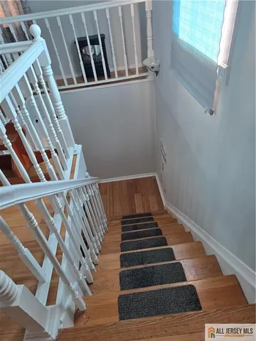 a view of staircase with railing and white walls