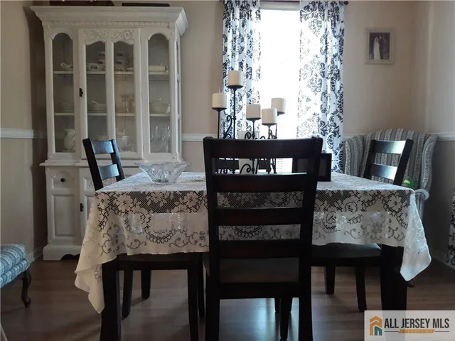 a front view of a dining room with furniture and wooden floor