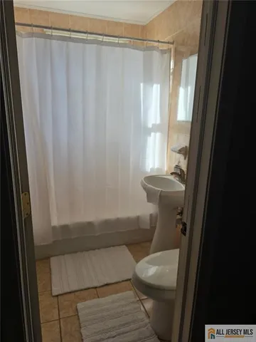 a bathroom with a toilet and a shower curtain