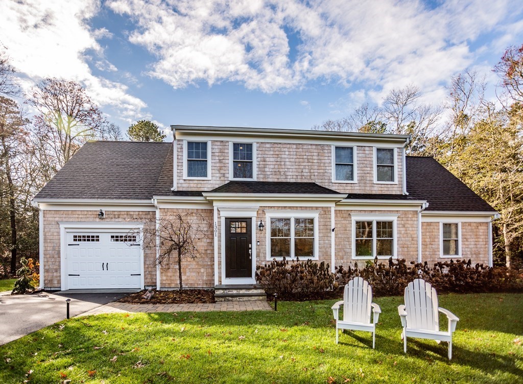 a front view of a house with a yard and trees