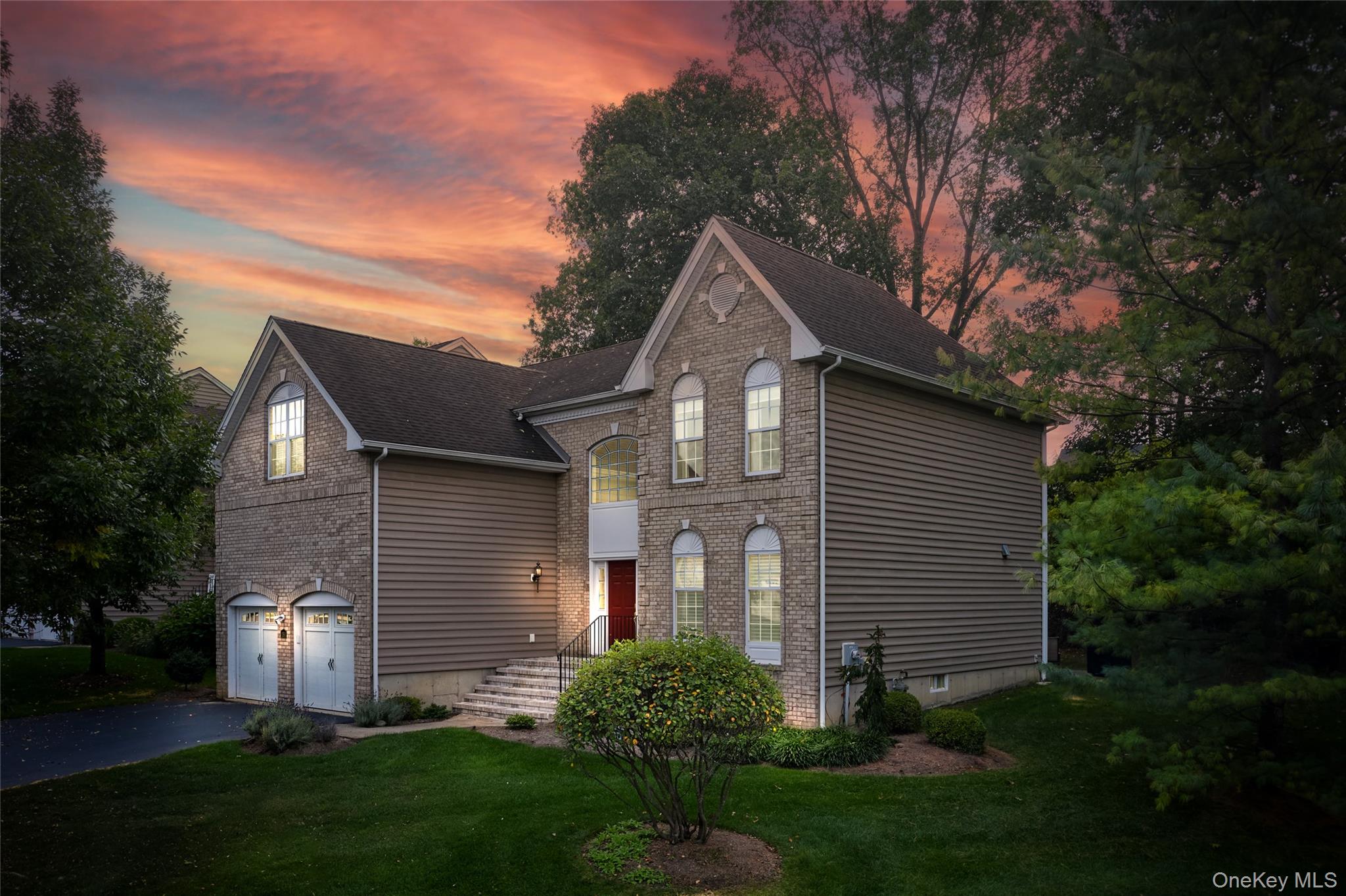 a front view of a house with a garden and plants