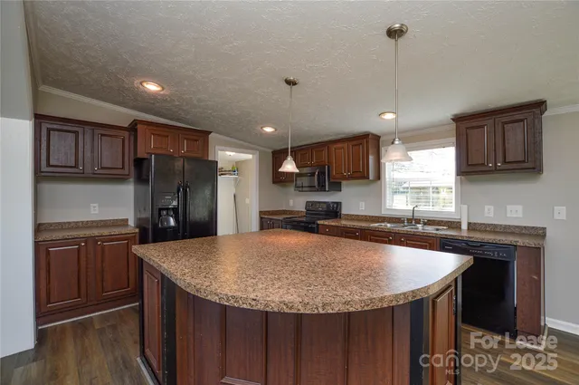 a kitchen with stainless steel appliances granite countertop a sink a refrigerator and a stove