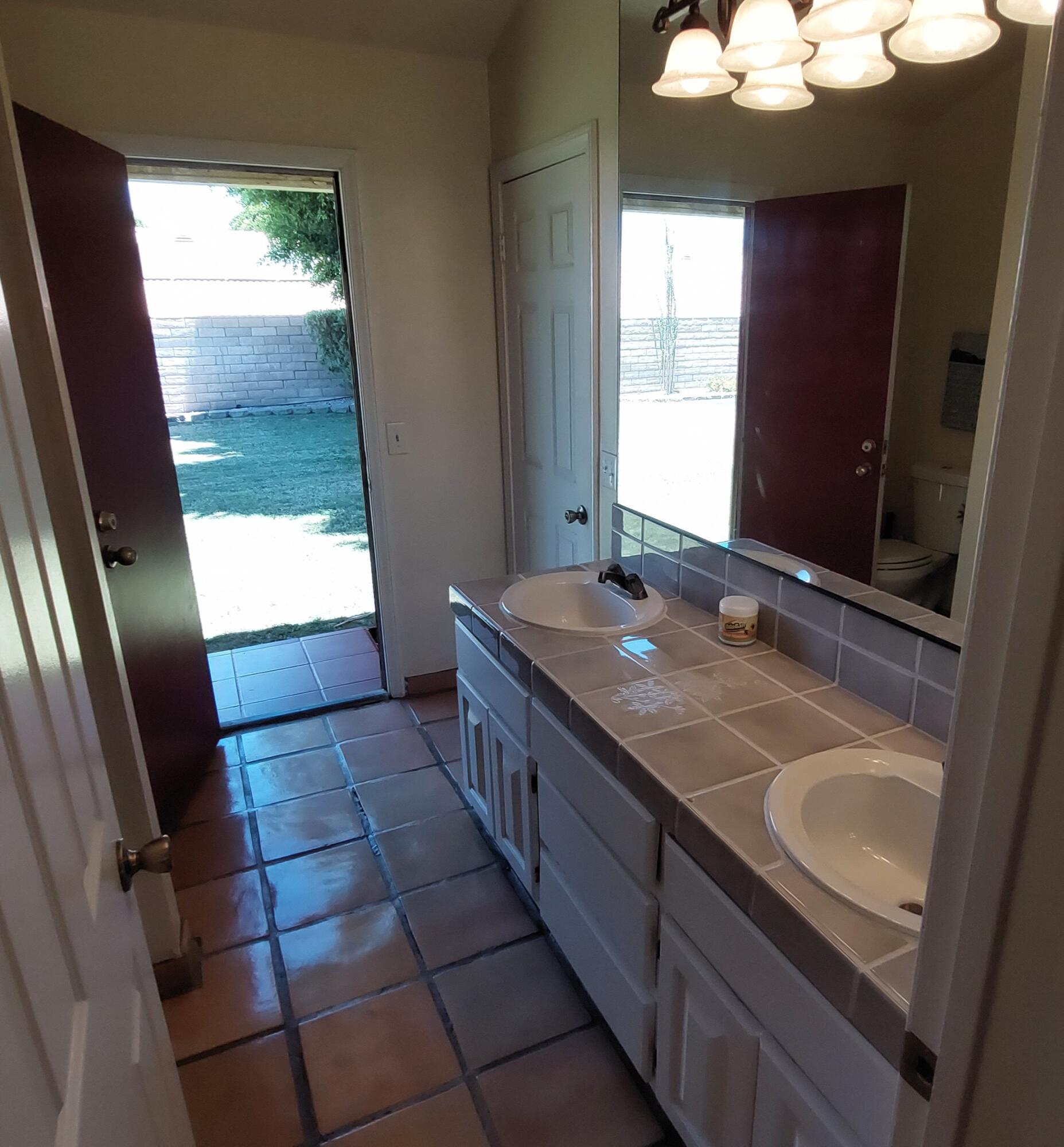 42710 Sandy Bay Road Bermuda Dunes, CA 92203 - Photo 23 of 37 a bathroom with a sink a vanity and a mirror