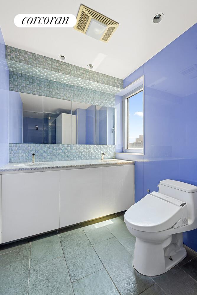 250 East 40th Street, Unit PH2A Manhattan, NY 10016 - Photo 17 of 25 a bathroom with a granite countertop toilet sink and mirror