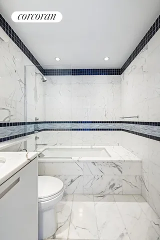 a bathroom with a granite countertop toilet sink and mirror