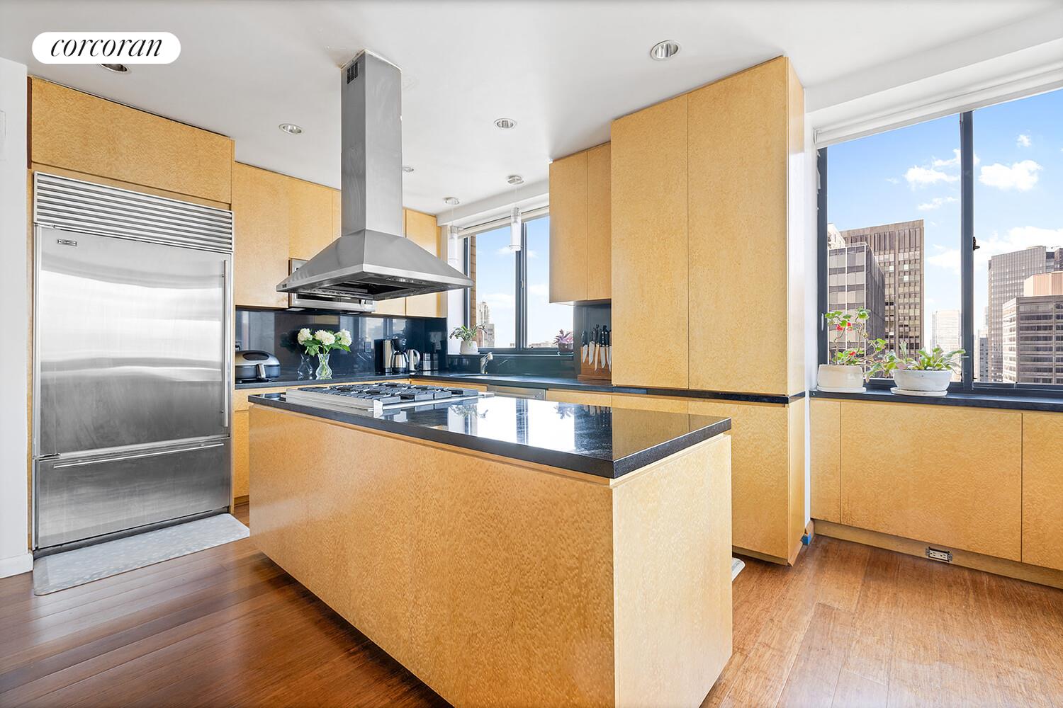 250 East 40th Street, Unit PH2A Manhattan, NY 10016 - Photo 9 of 25 a kitchen with stainless steel appliances granite countertop a refrigerator a stove and a sink with wooden floor