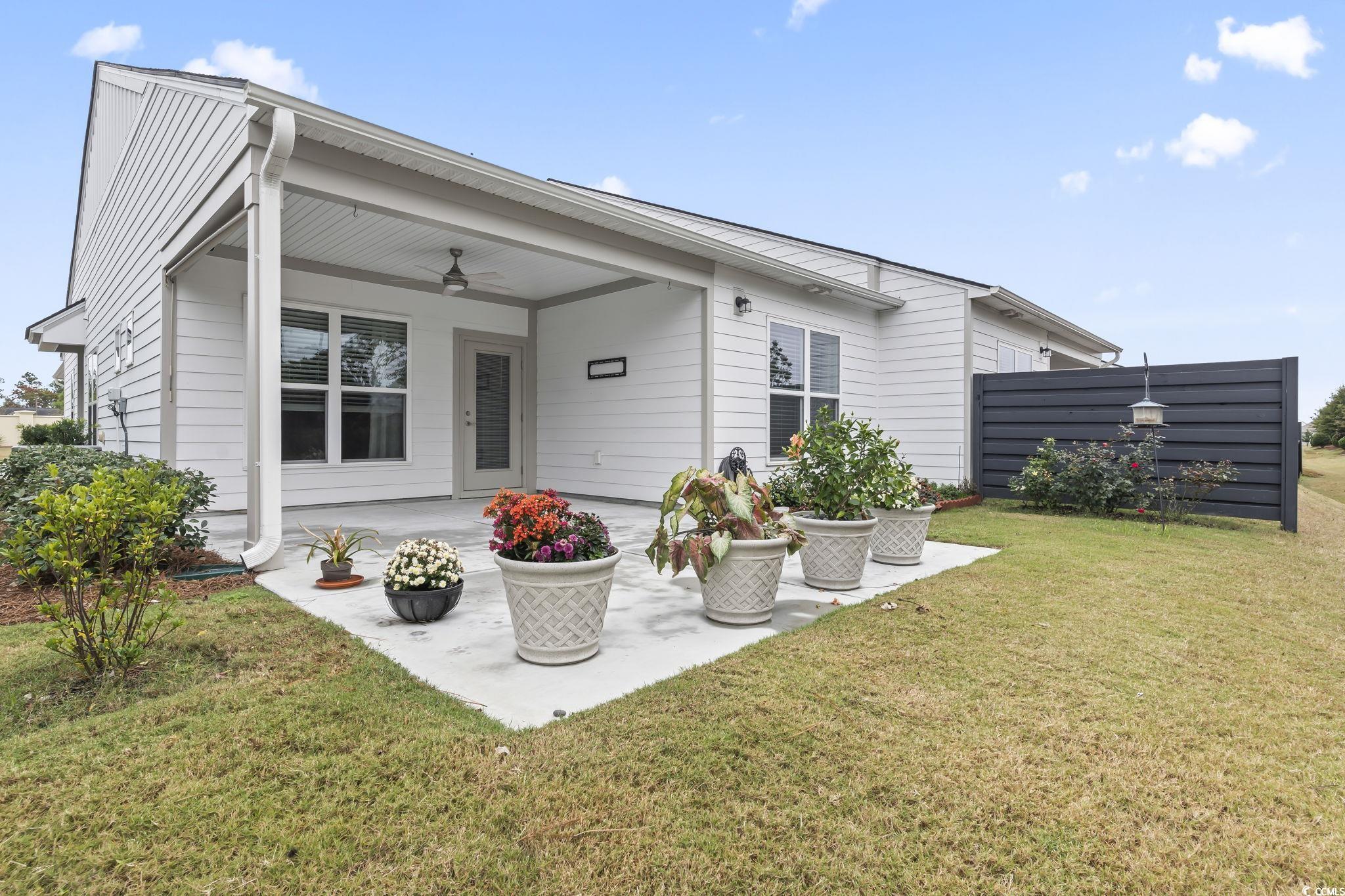 6570 Torino Lane Myrtle Beach, SC 29572 - Photo 14 of 25 Back of property with a ceiling fan, a patio area, and a lawn
