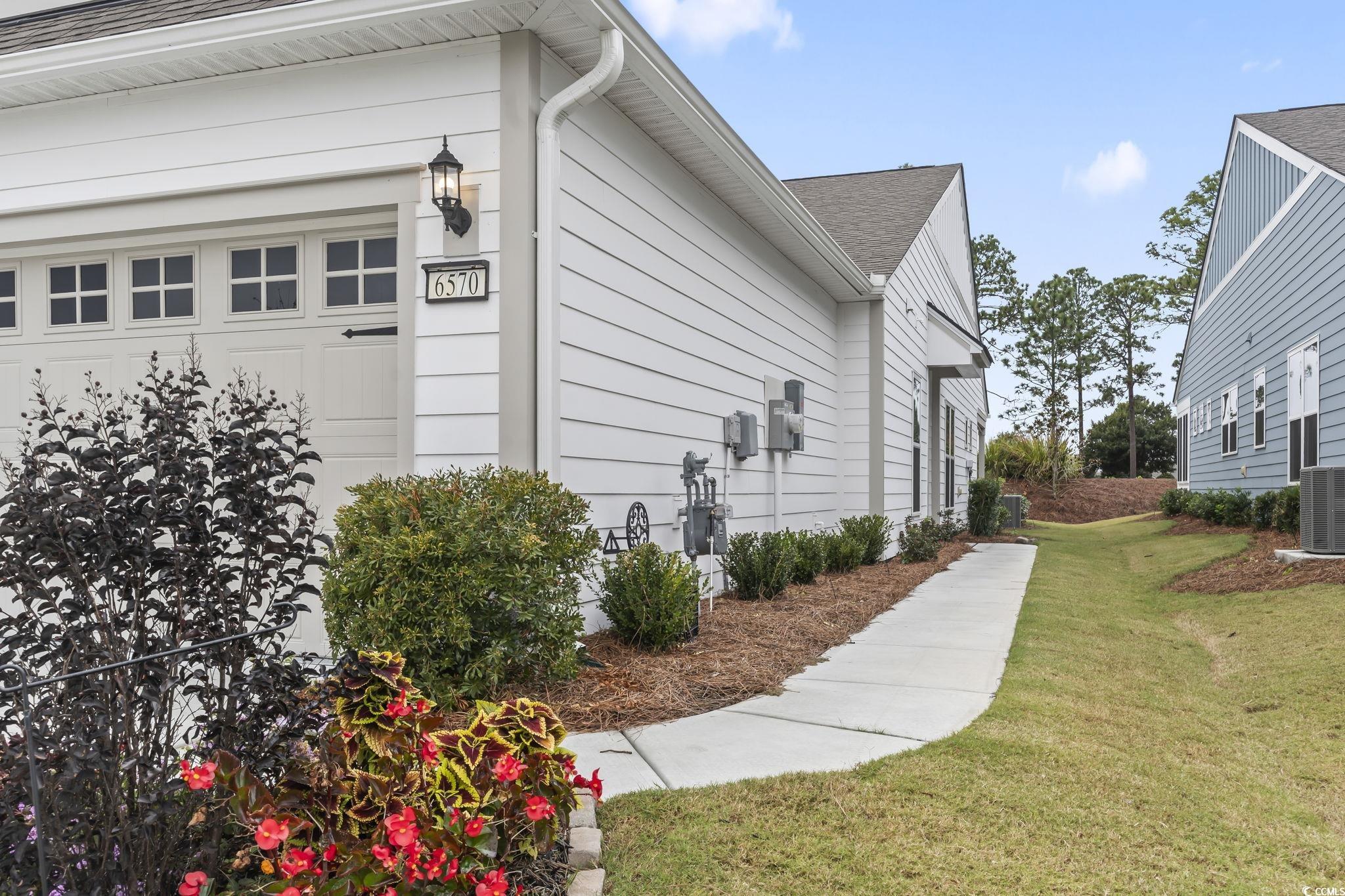 6570 Torino Lane Myrtle Beach, SC 29572 - Photo 19 of 25 View of home's exterior featuring a yard and roof with shingles