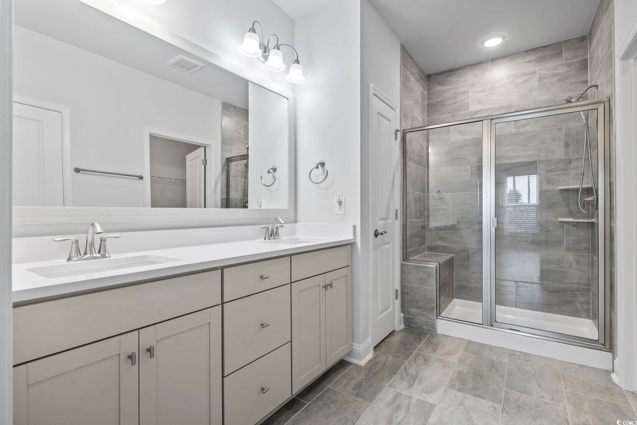 6570 Torino Lane Myrtle Beach, SC 29572 - Photo 5 of 25 Bathroom with double vanity, a shower stall, a spacious closet, and recessed lighting
