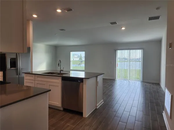 a kitchen with stainless steel appliances granite countertop wooden floors and sink