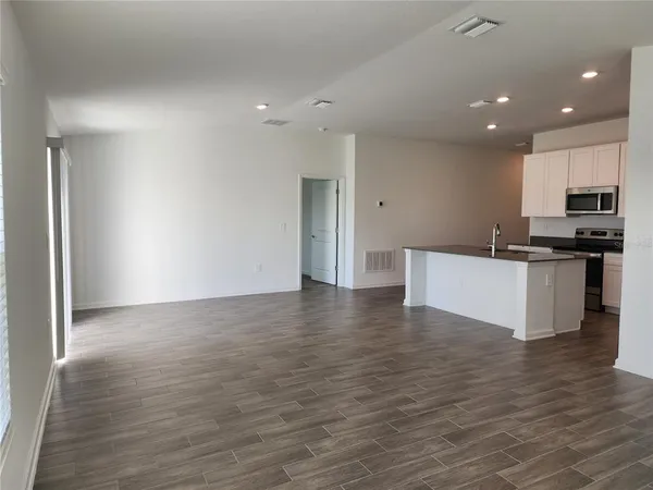 a view of kitchen with microwave and white cabinets