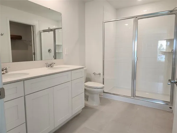 a spacious bathroom with a shower sink vanity mirror and toilet