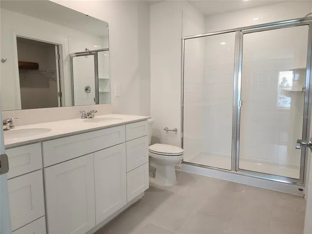 a spacious bathroom with a shower sink vanity mirror and toilet