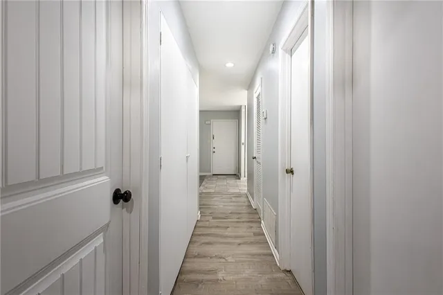 a view of a hallway with wooden floor and a door