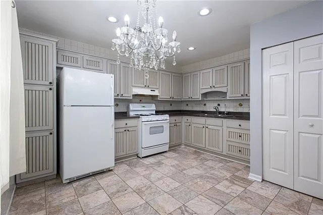 a kitchen with white cabinets and white appliances