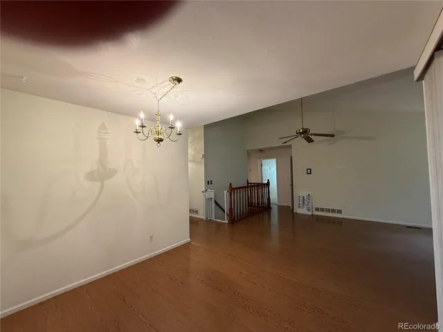 en empty room with windows and ceiling fan
