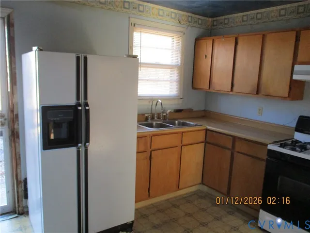 a kitchen with stainless steel appliances granite countertop a refrigerator sink and cabinets
