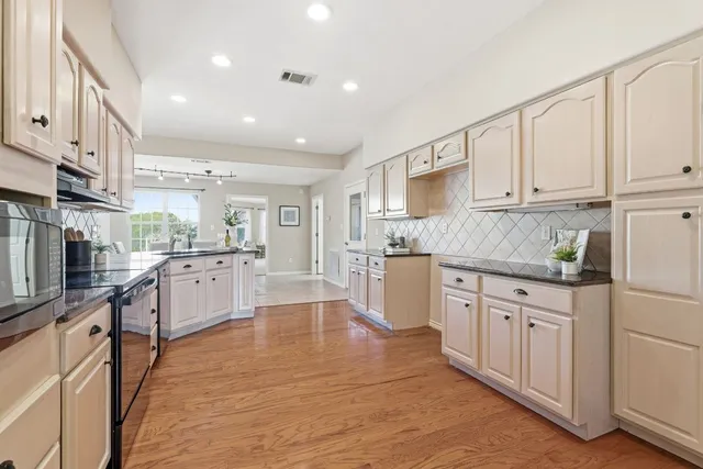 a large kitchen with stainless steel appliances cabinets a sink and a counter top space
