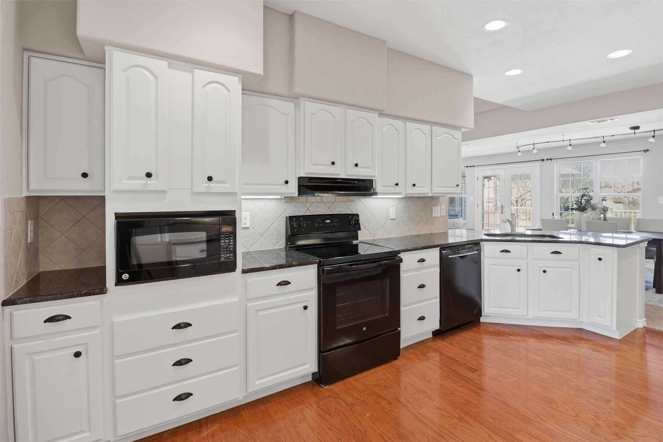 200 Apache Trail Burnet, TX 78611 - Photo 14 of 40 Kitchen featuring black appliances, white cabinets, backsplash, light wood-type flooring, and recessed lighting