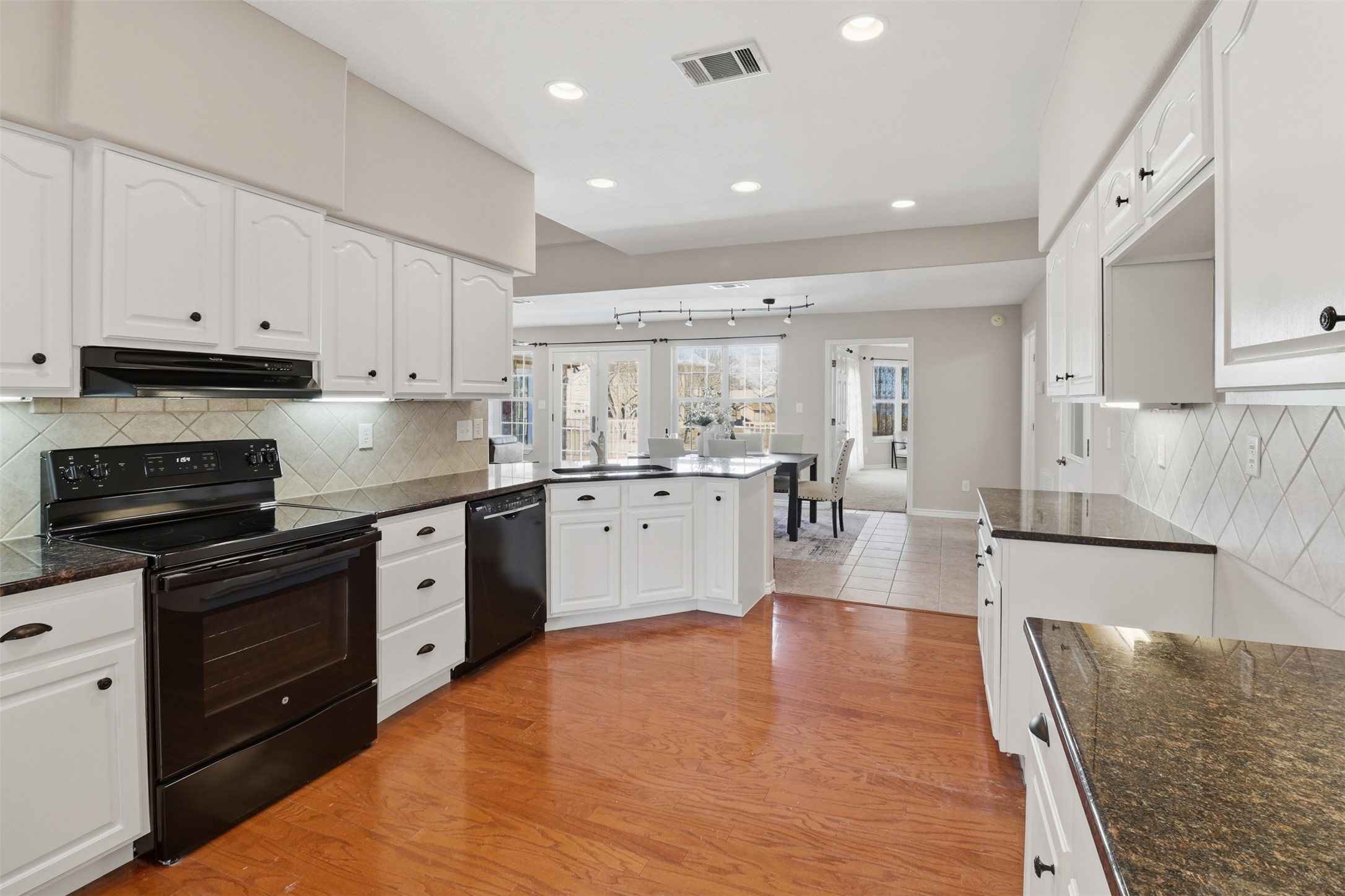 200 Apache Trail Burnet, TX 78611 - Photo 15 of 40 Kitchen with backsplash, black appliances, white cabinetry, light wood-style floors, and recessed lighting
