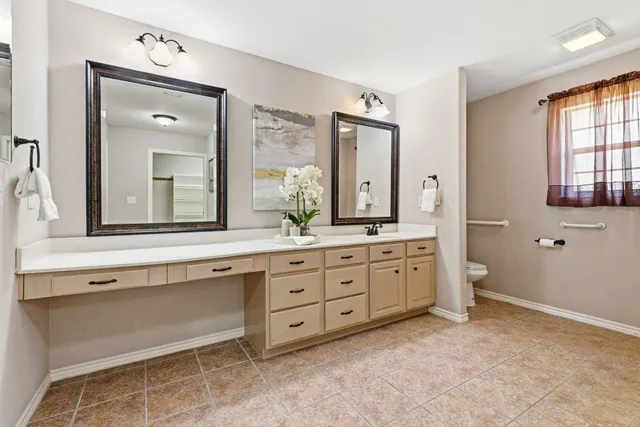 a spacious bathroom with a granite countertop sink mirror and bathtub