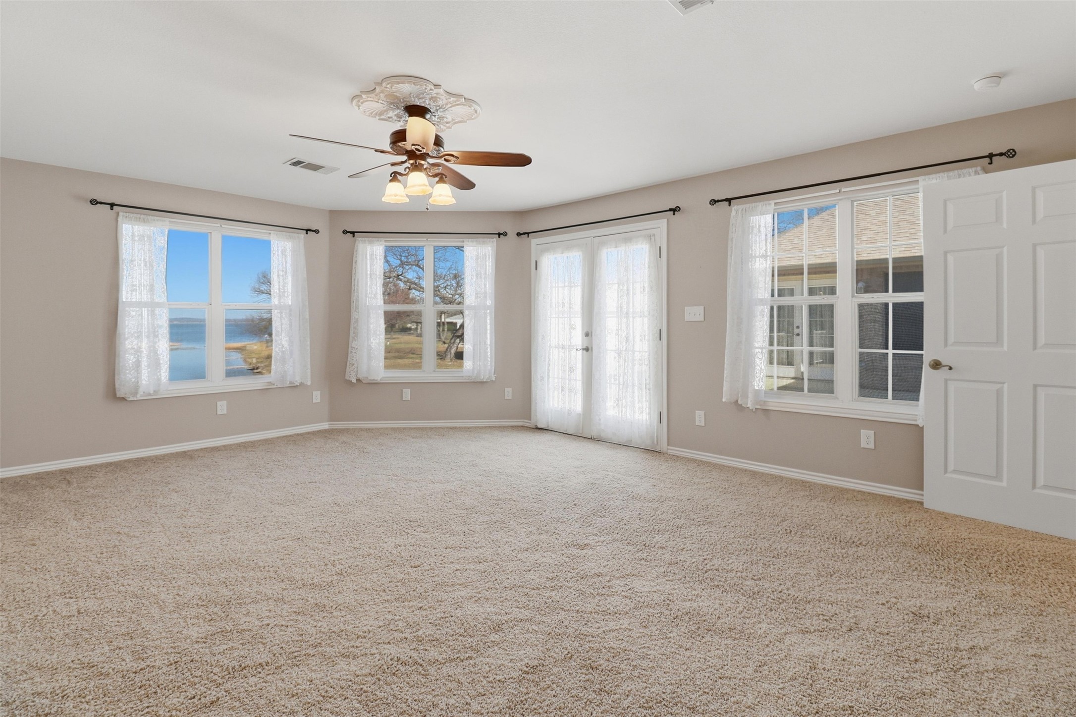 200 Apache Trail Burnet, TX 78611 - Photo 23 of 40 Empty room with plenty of natural light, french doors, light carpet, and a ceiling fan