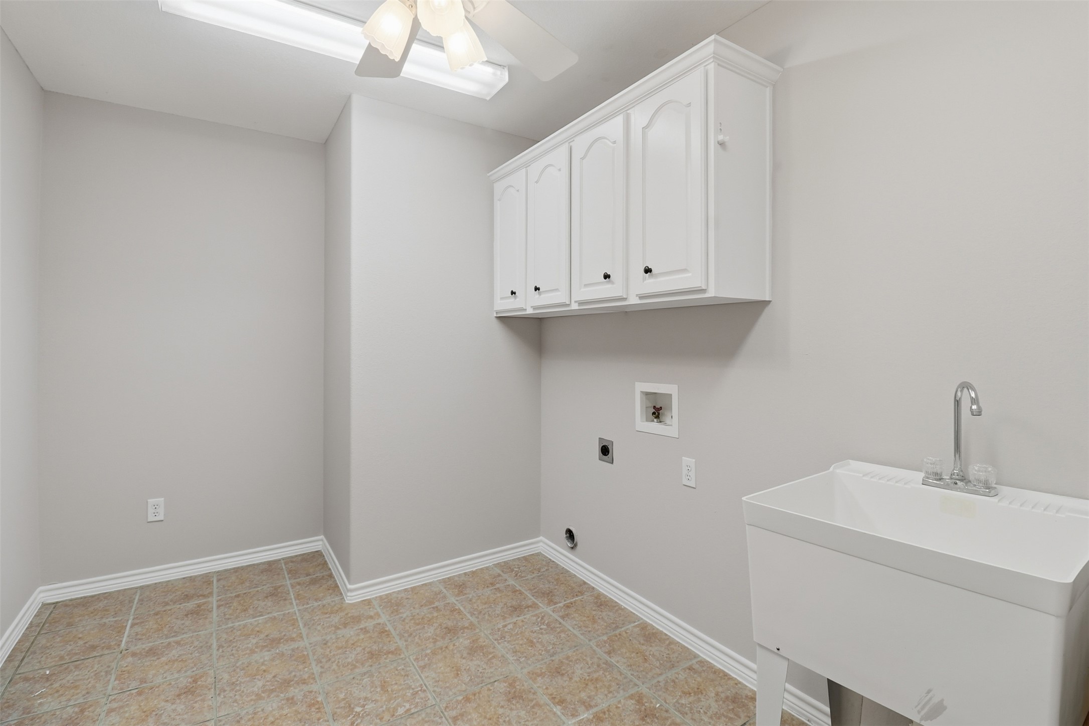200 Apache Trail Burnet, TX 78611 - Photo 30 of 40 Laundry room featuring hookup for an electric dryer, hookup for a washing machine, a ceiling fan, cabinet space, and light tile patterned floors