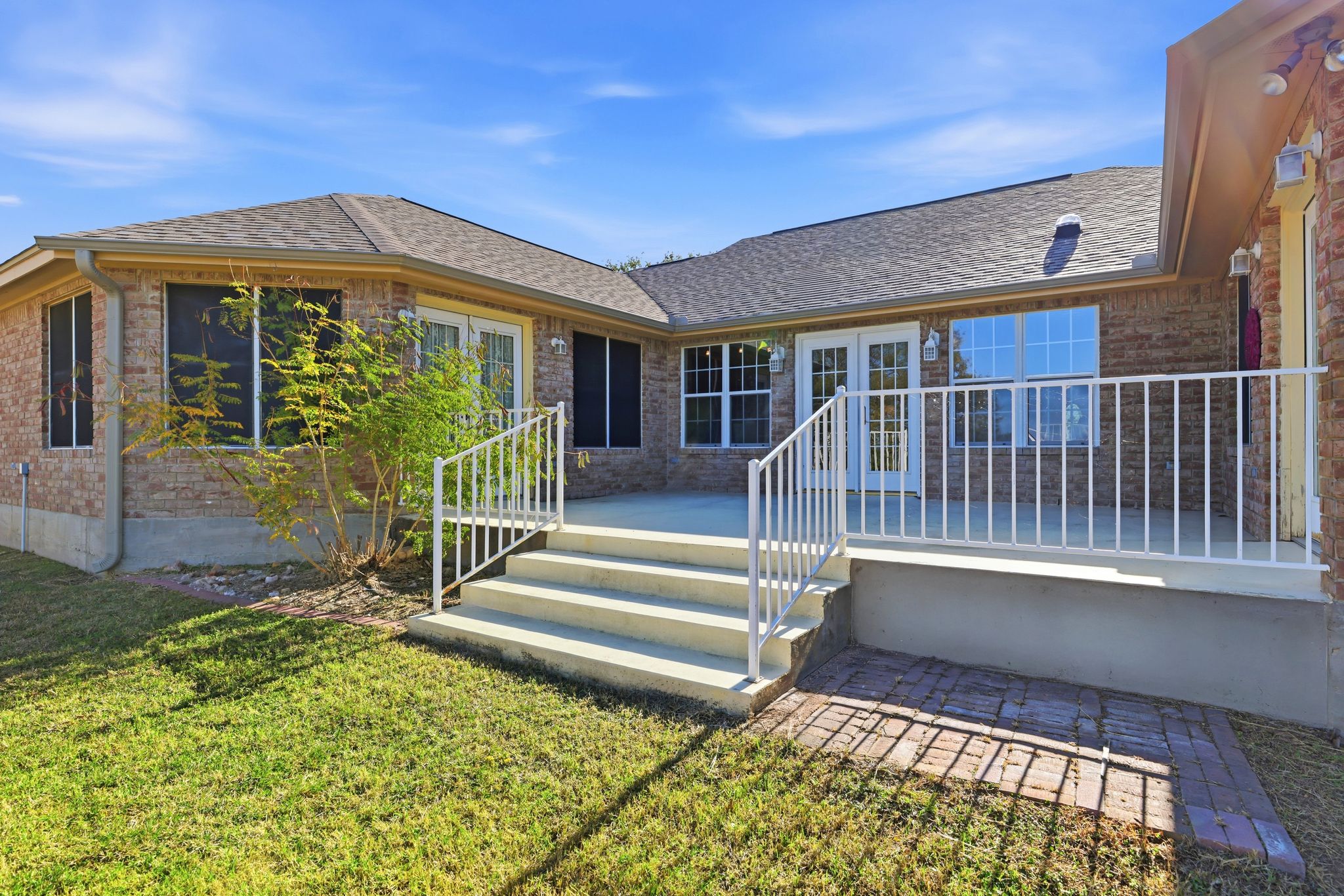 200 Apache Trail Burnet, TX 78611 - Photo 34 of 40 Back of property featuring french doors, brick siding, a deck, a shingled roof, and a patio