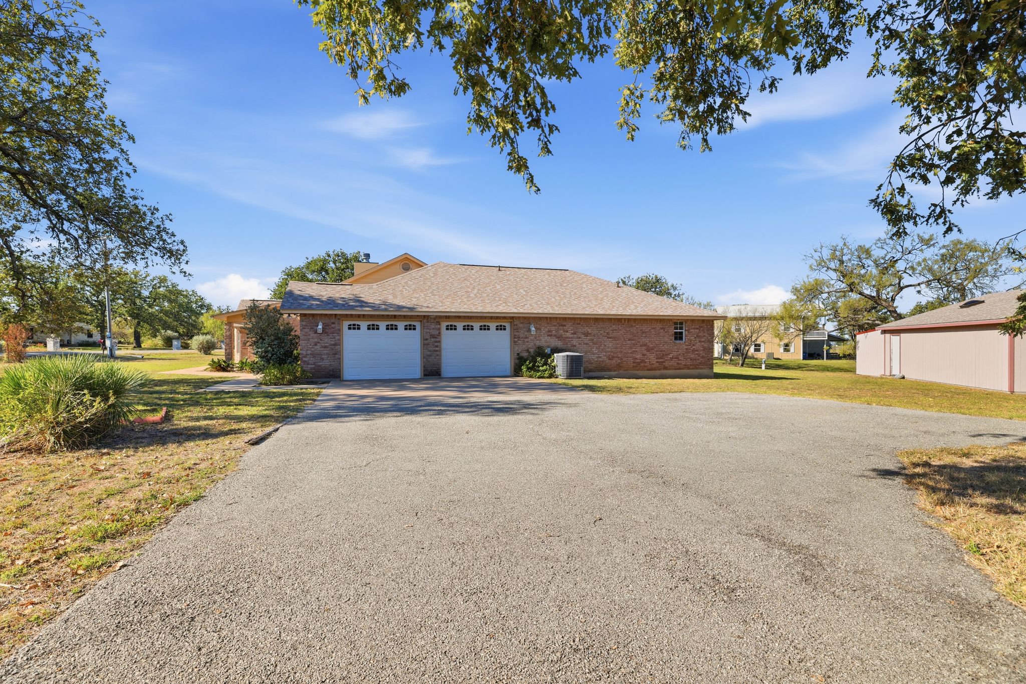 200 Apache Trail Burnet, TX 78611 - Photo 36 of 40 Ranch-style home with driveway, a front lawn, brick siding, and a garage