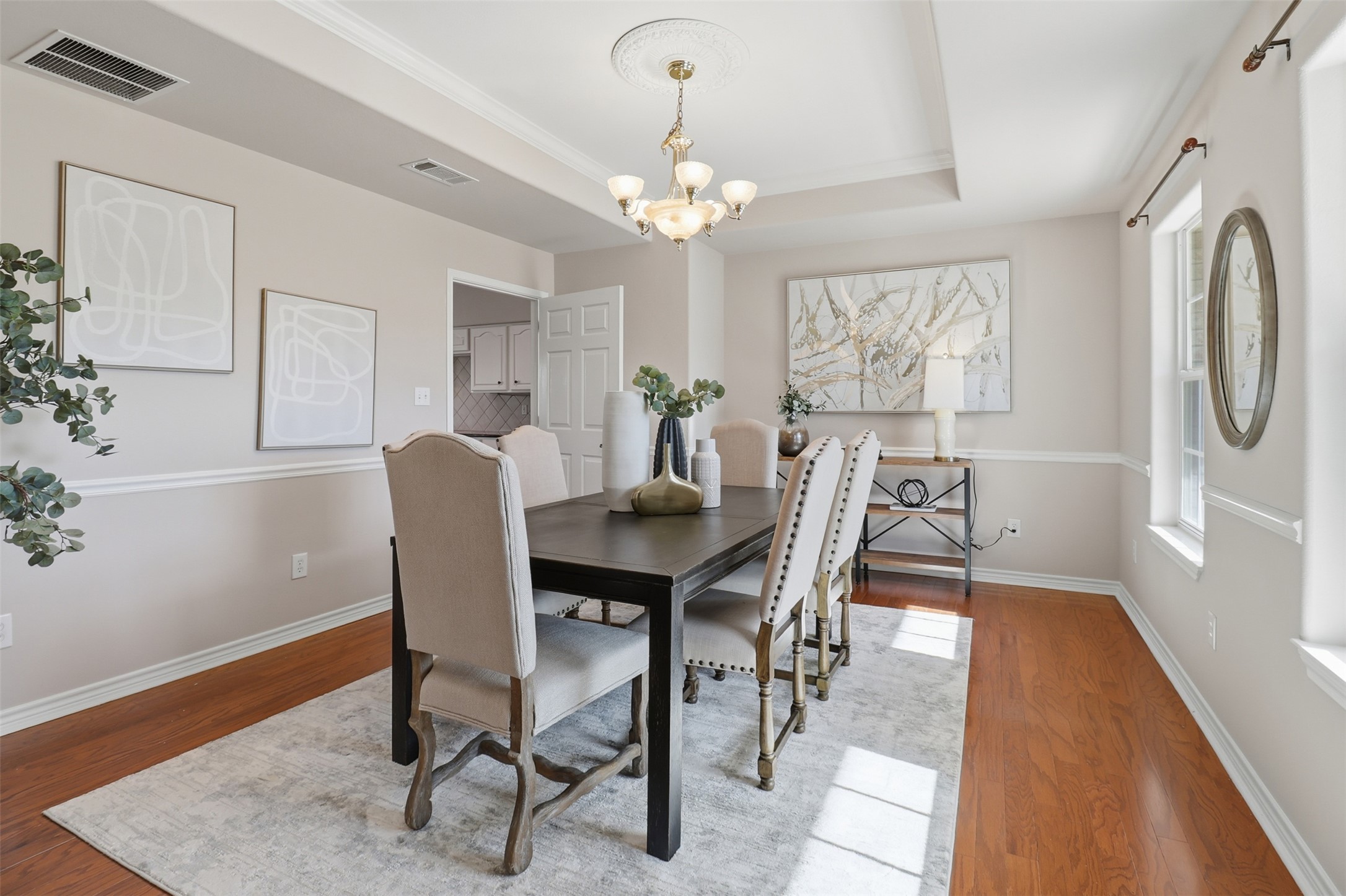 200 Apache Trail Burnet, TX 78611 - Photo 4 of 40 Dining room featuring wood finished floors, a chandelier, a raised ceiling, and ornamental molding