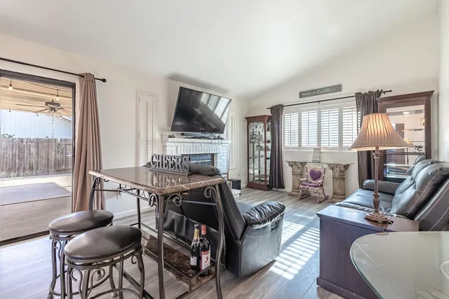 a living room with furniture a flat screen tv and a large window