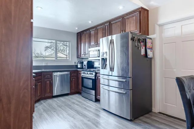 a kitchen with stainless steel appliances a refrigerator and a stove top oven