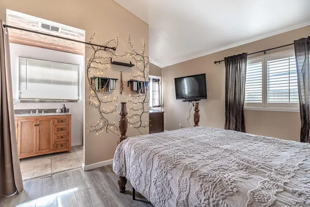 a spacious bedroom with a bed and a flat screen tv