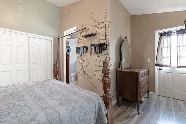 a bedroom with a bed and a flat tv screen on the dresser