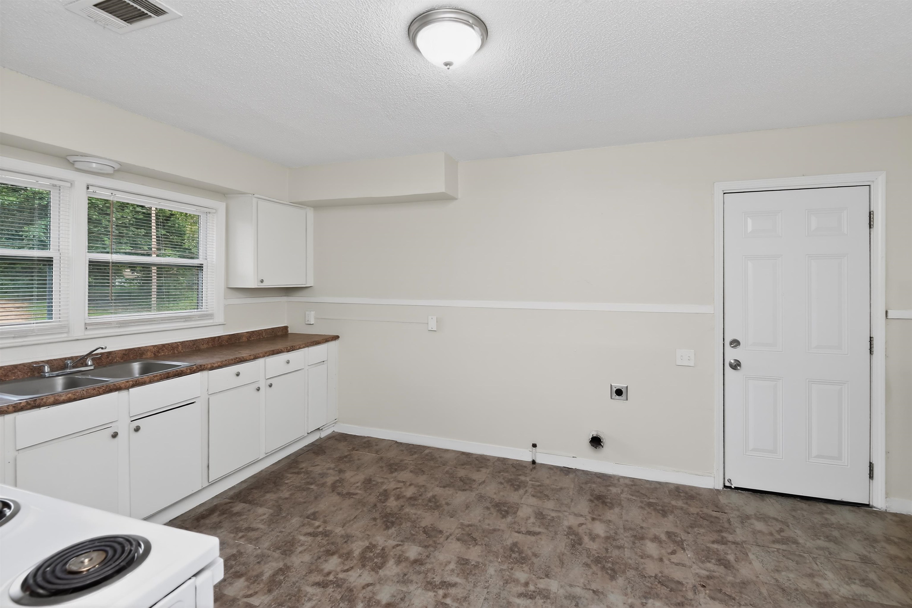 318 East Raines Road Memphis, TN 38109 - Photo 19 of 28 Functional kitchen space featuring white cabinetry, a double basin stainless steel sink, and a brown laminate countertop