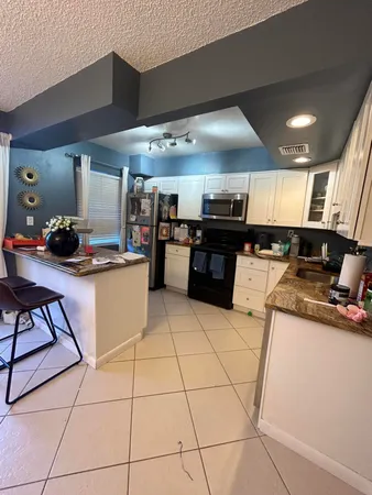 a kitchen with stainless steel appliances kitchen island granite countertop a sink and cabinets