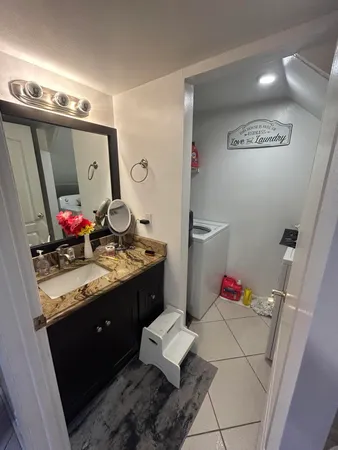 a bathroom with a granite countertop sink and a mirror