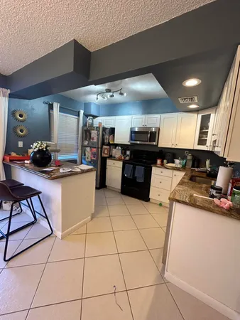 a kitchen with stainless steel appliances kitchen island granite countertop a sink and cabinets