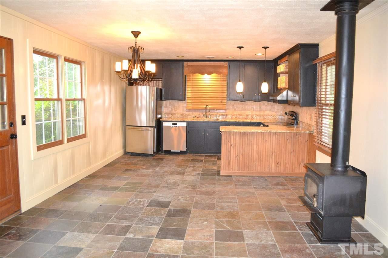 10769 Beaver Dam Road Middlesex, NC 27557 - Photo 6 of 14 a kitchen with granite countertop a stove a sink and a refrigerator