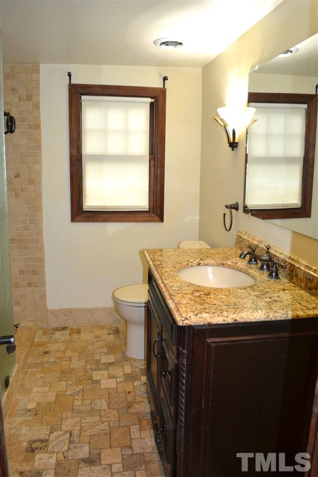 10769 Beaver Dam Road Middlesex, NC 27557 - Photo 10 of 14 a bathroom with a granite countertop sink a toilet and a mirror